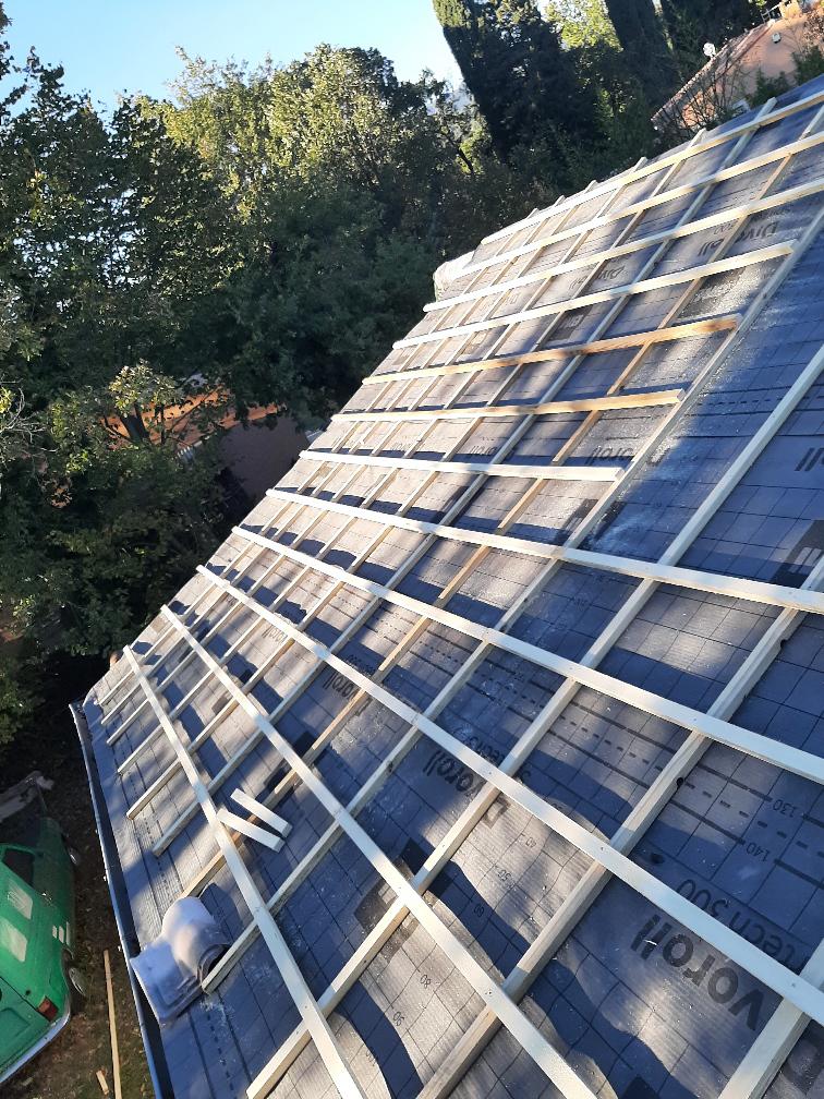 Couvreur au travail sur une toiture à La Chapelle‑en‑Serval